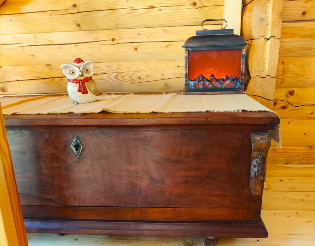 rustikalna skrinja in mini kamin v leseni hiški na Goričkem